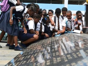 Students of the Tivoli Gardens High School look at the names of children who died under tragic/violent circumstances at the Secret Gardens, downtown Kingston, on Tuesday as they commemorate Peace Day. - PHOTO BY ERROL CROSBY/Gleaner