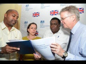 David Fitton (right), British high commissioner to Jamaica, looks at the Peace Management Initiative (PMI) Report on Homeless Youth with Julian Robinson (left), member of parliament for South East St Andrew; Julia Sutherland, deputy British high commissioner, and Damian Hutchinson, executive director of the PMI, at the high commission's presentation of the report at the British High Commission in New Kingston. (Photo: Rudolph Brown/Gleaner)