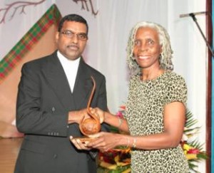 Father Sean Major-Campbell receives his Ubuntu Essence of Humanity award from Dr. Elaine Wallace, Registrar and Chair, Fi Wi Jamaica Project Steering Committee, University of Technology. 